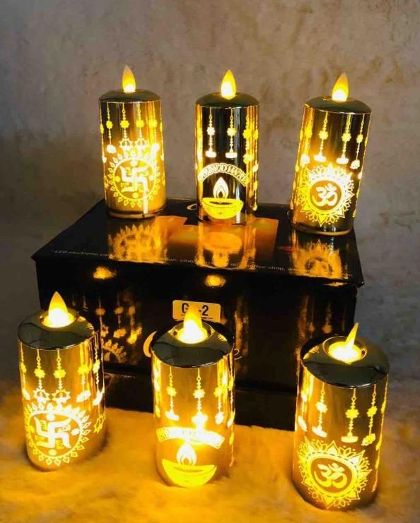 Set of decorative candles with illuminated designs on a reflective surface.